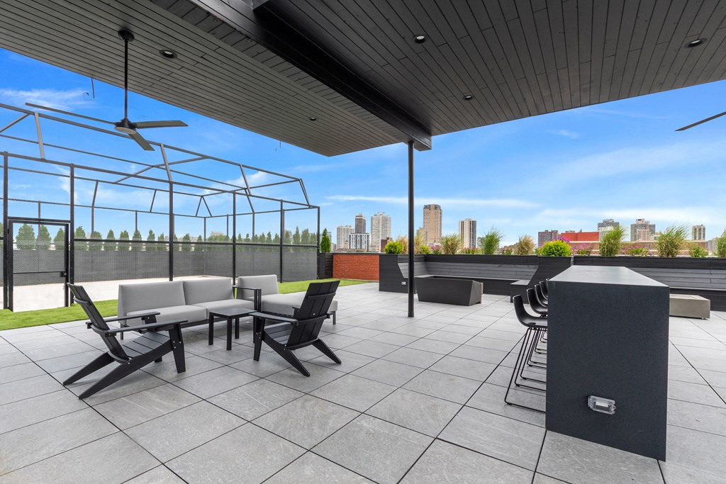 a rooftop patio with a fire pit and a view of the city