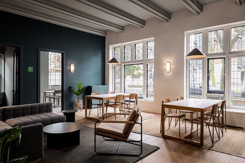 a living room with tables and chairs and a large window