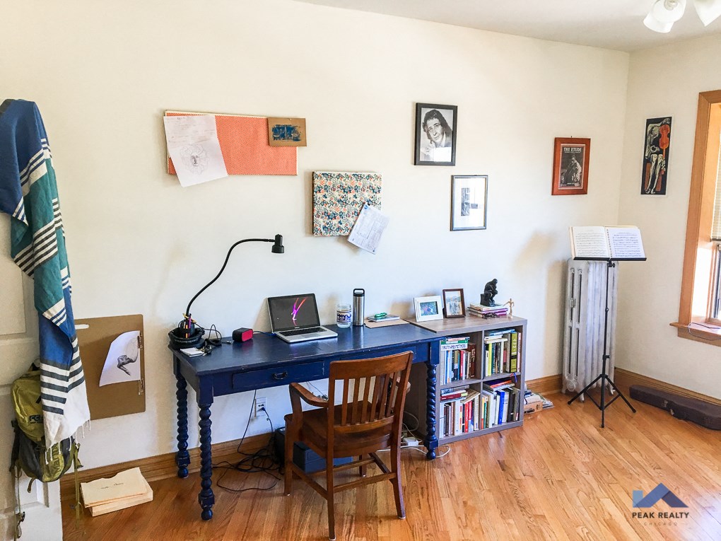 a home office with a blue desk and a bookcase with a laptop