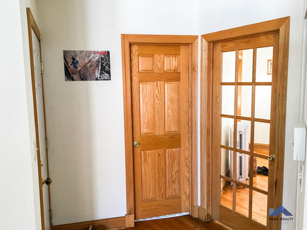 two wooden doors in a room next to a window