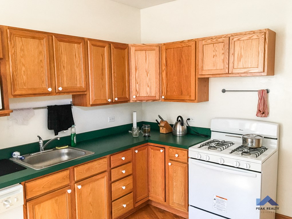 a kitchen with wooden cabinets and green counter tops and a white stove top oven
