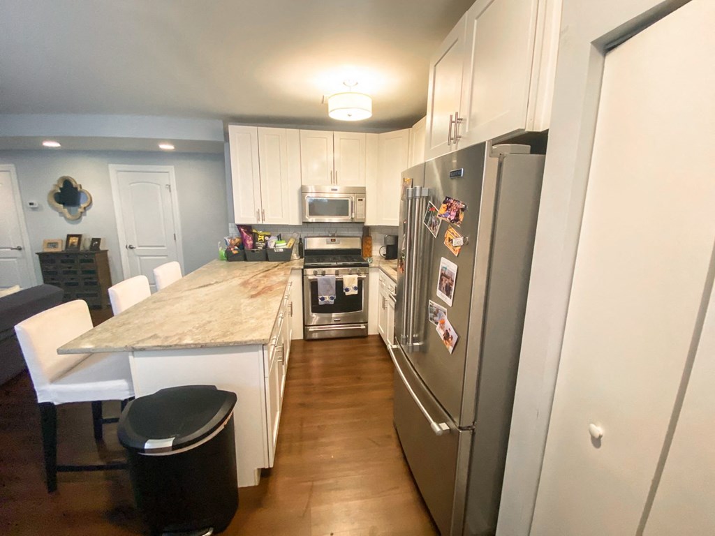 a kitchen with white cabinets and stainless steel appliances