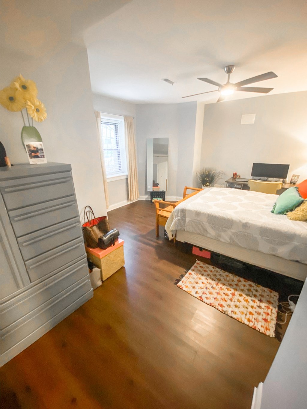 a bedroom and living room with a bed and a dresser