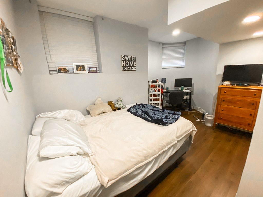 a bedroom with a bed and a dresser and a tv