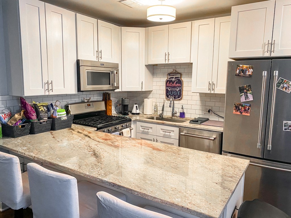a kitchen with a large counter top and stainless steel appliances