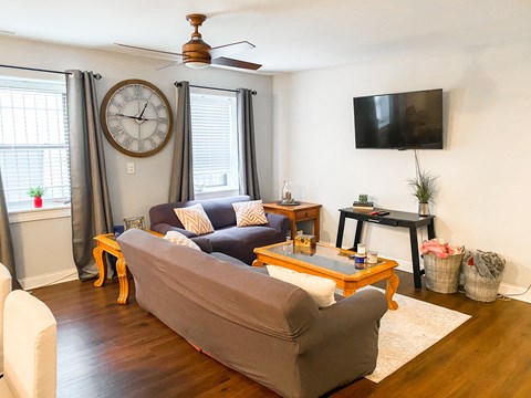 a living room with a couch and a clock on the wall