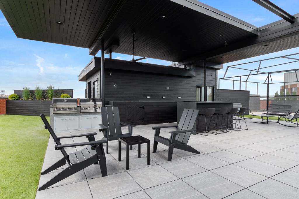 a large patio with a bar and chairs