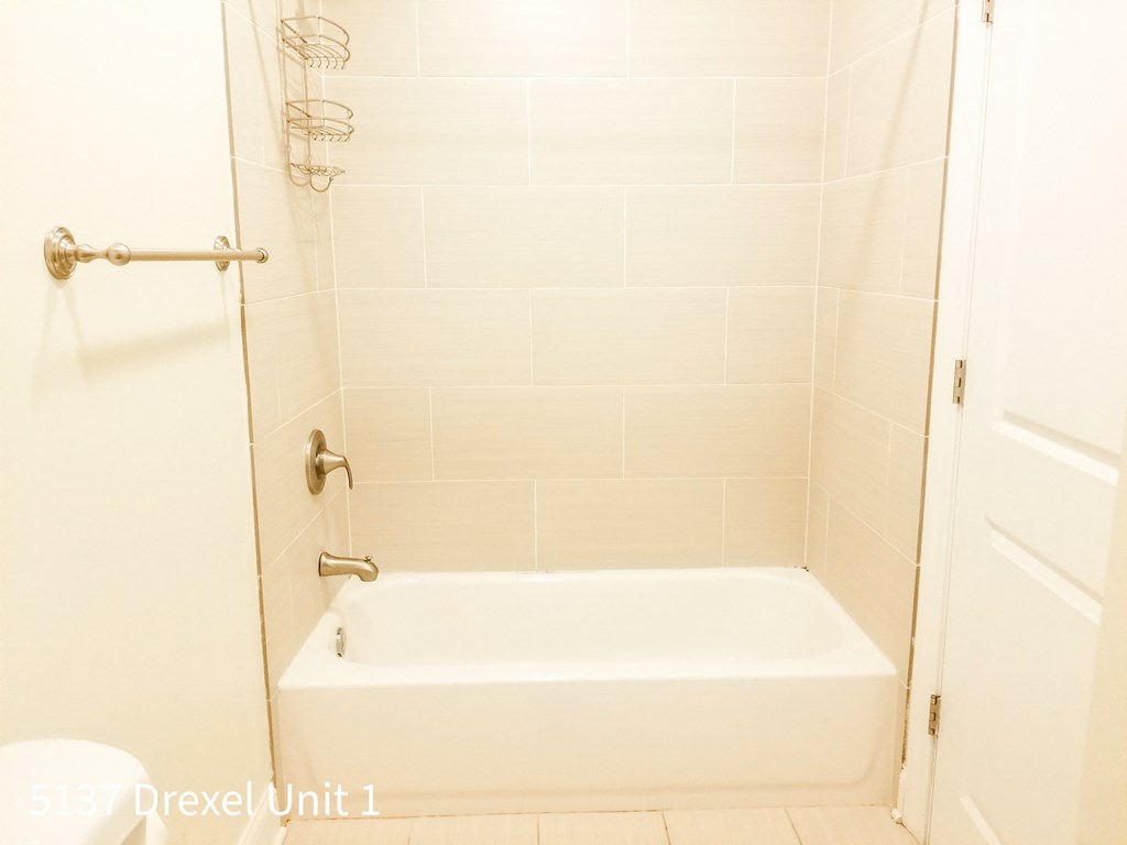 a white bathroom with a tub and a shower curtain