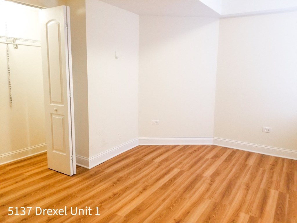a room with wooden floors and white walls and a closet
