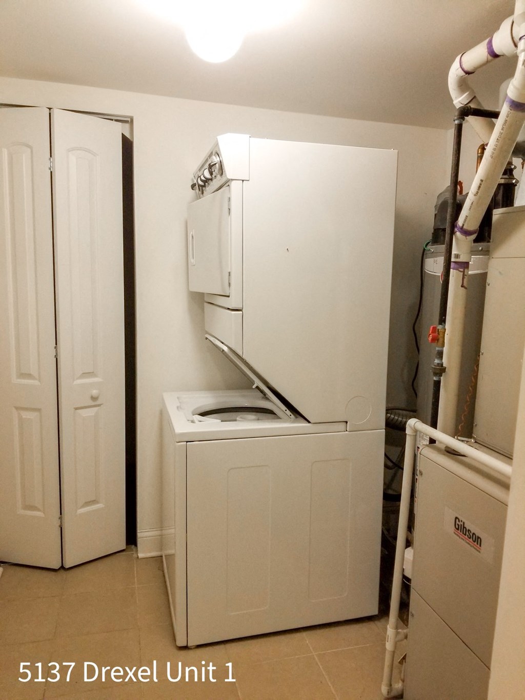 a white washer and dryer in a room with a sink and a refrigerator