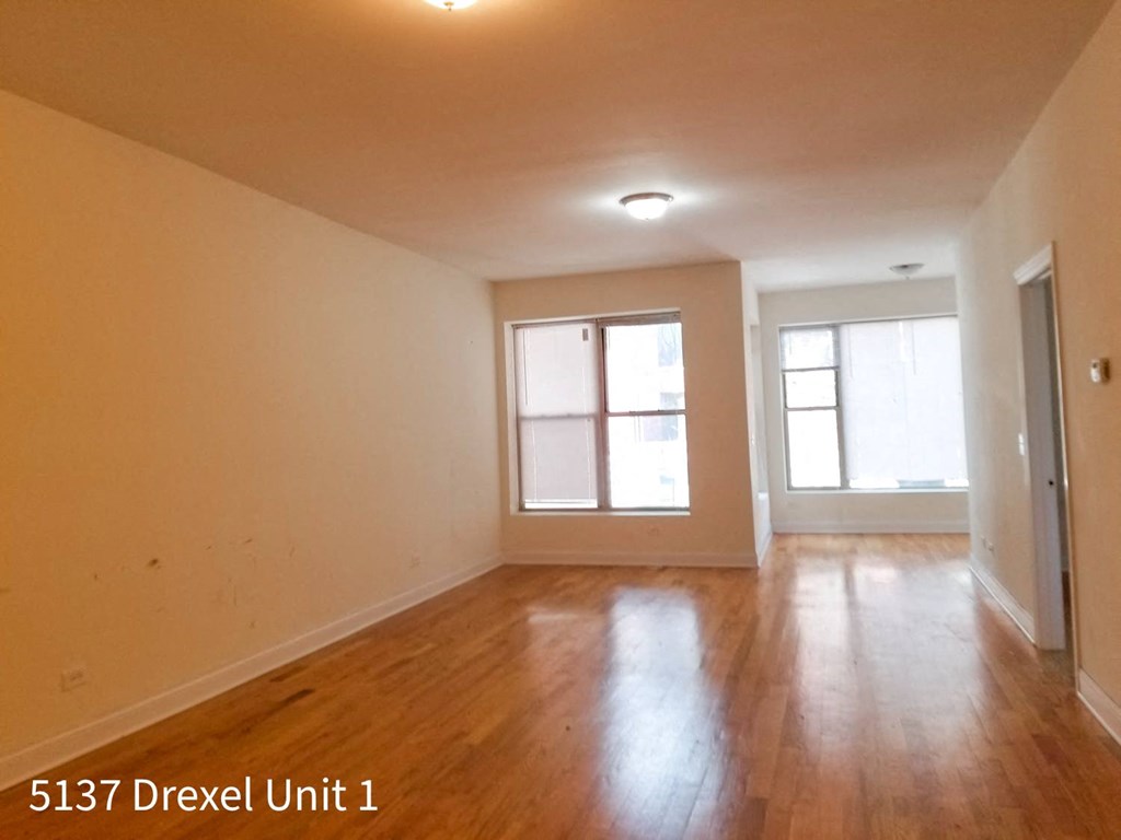 the interior of an empty living room with wood floors and a window
