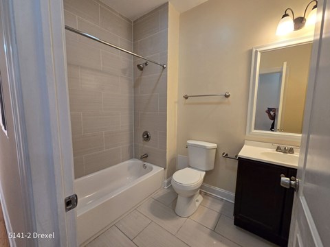 a bathroom with a toilet and a tub and a sink