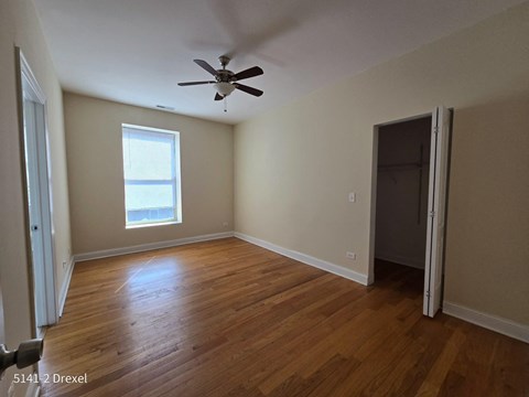 an empty living room with wooden floors and a ceiling fan