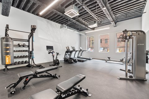 a gym with exercise equipment and weights on the floor