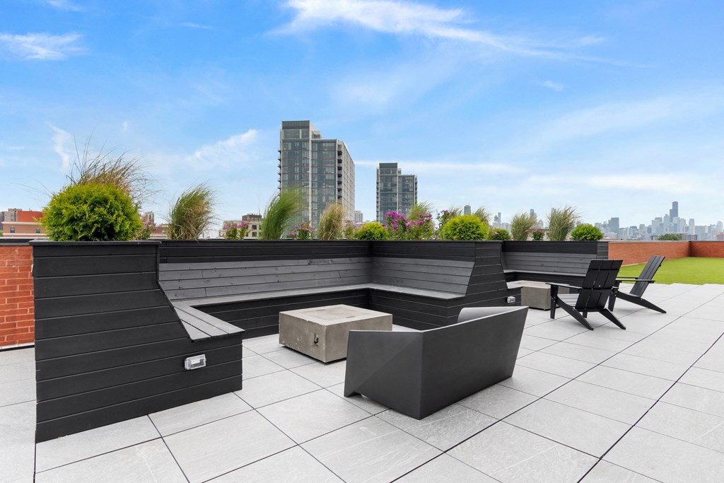 a roof deck with a seating area and a fire pit