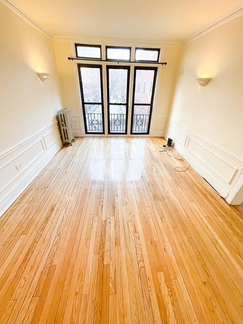 A room with wooden floors and a large window.