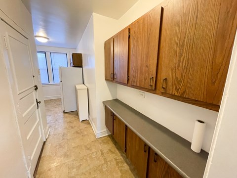 A kitchen with wooden cabinets and a white fridge.