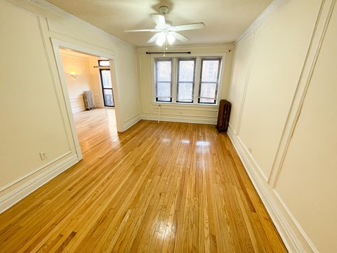 A room with wooden floors and a ceiling fan.