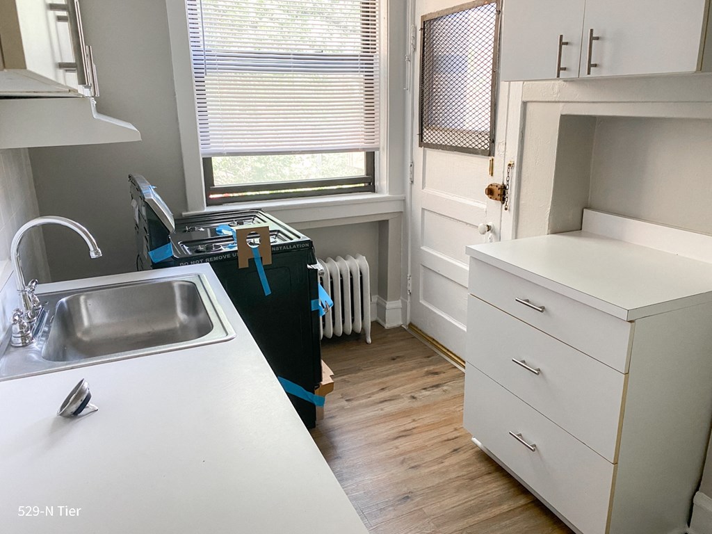 a small kitchen with white cabinets and a sink