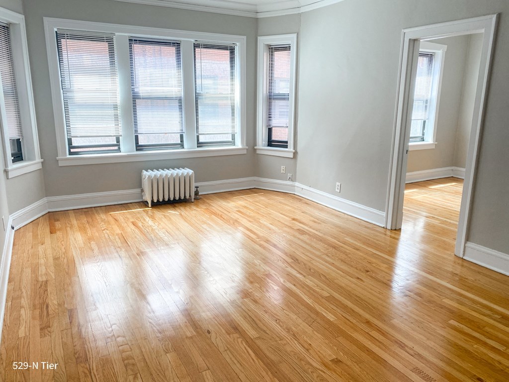 an empty living room with wood floors and windows