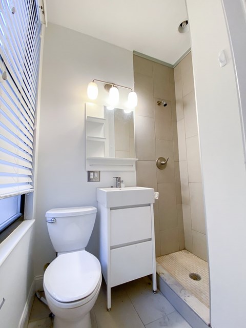 A white toilet sits next to a sink in a small bathroom.