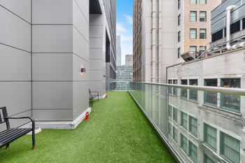 a balcony with a grassy area and a bench on it