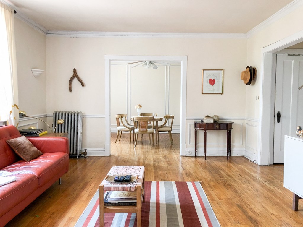 a living room with a red couch and a table and chairs