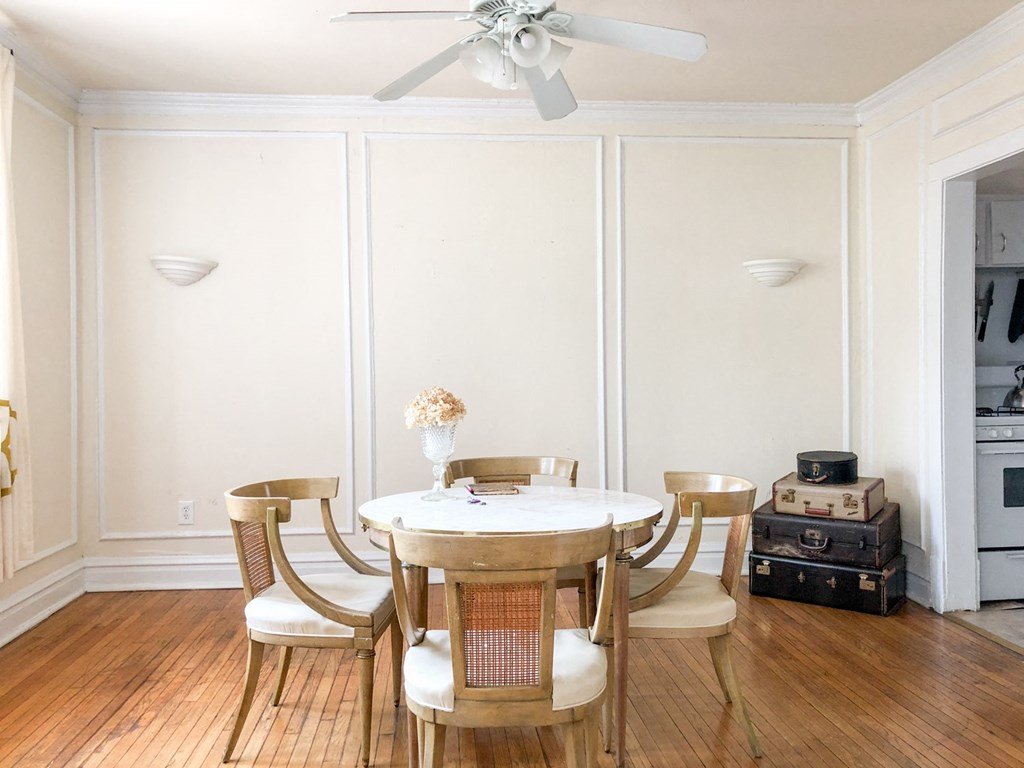a dining room with a table and chairs and a ceiling fan