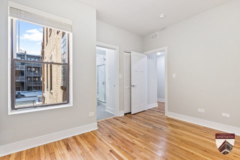 a living room with a large window and a door to a hallway