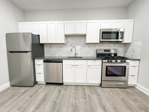 a kitchen with stainless steel appliances and white cabinets