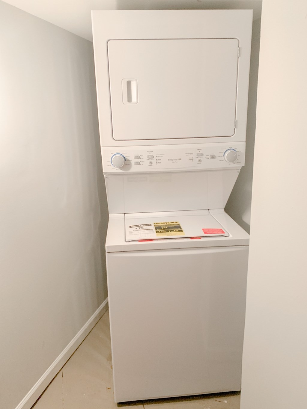 A white dryer is sitting in a corner.