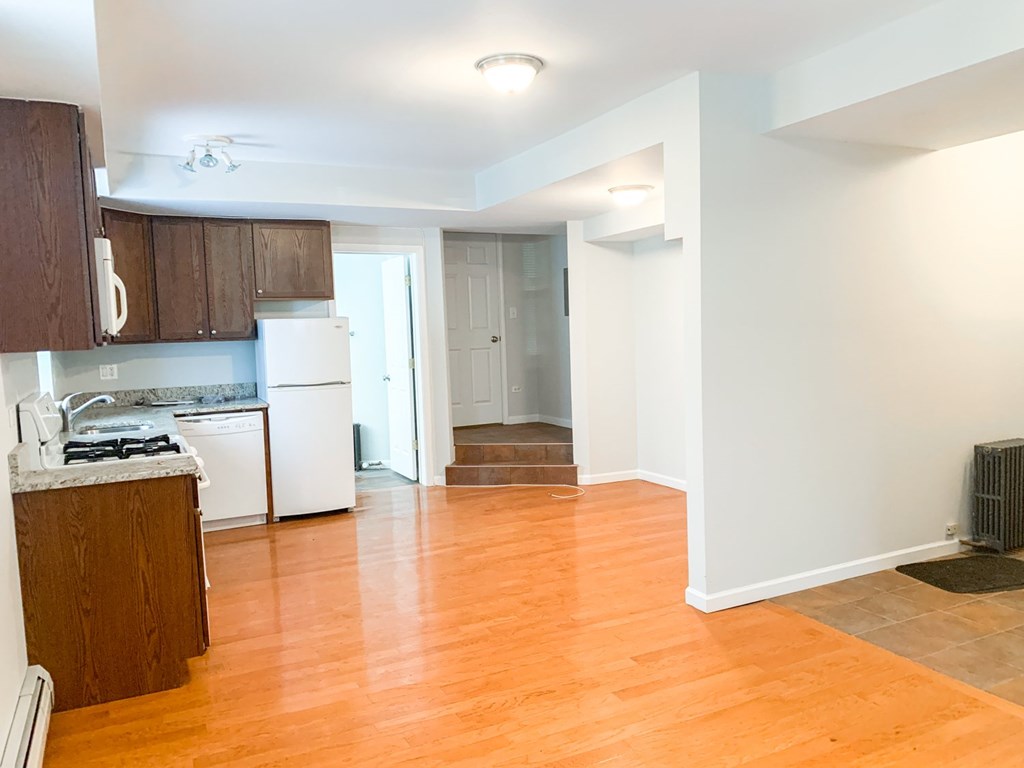 A kitchen with wooden cabinets and a white dishwasher.