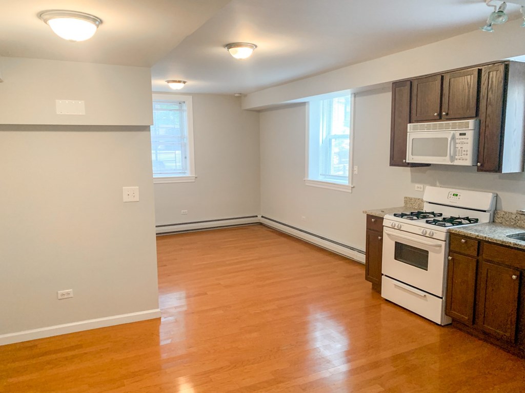 A kitchen with a stove, microwave, and oven.
