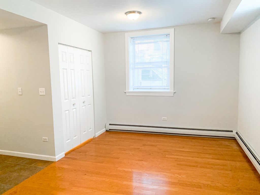A room with a wooden floor and a window.