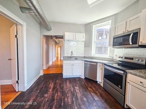 a kitchen with white cabinets and stainless steel appliances