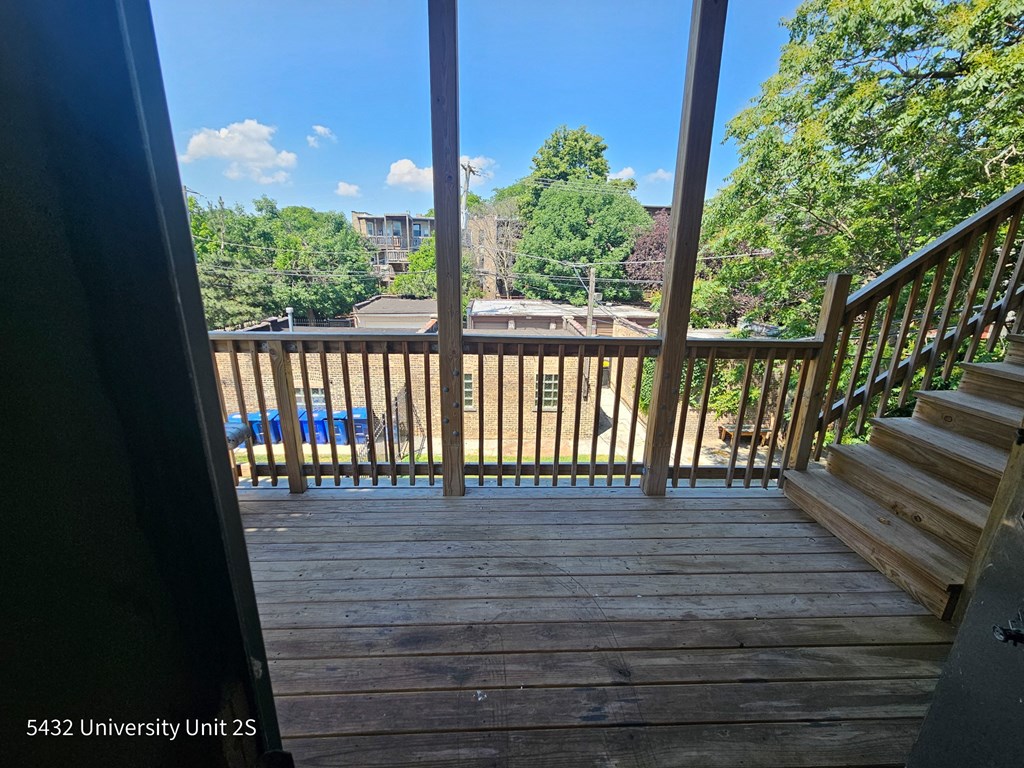 the view from the top of the stairs of a deck overlooking a pool and trees