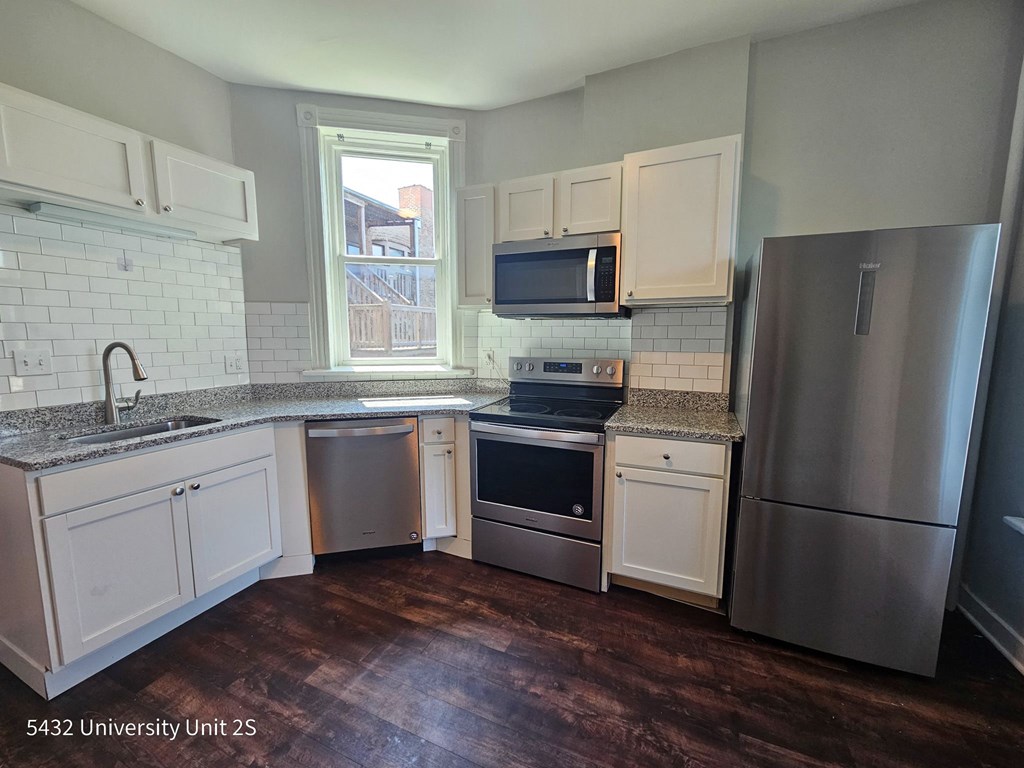a kitchen with white cabinets and stainless steel appliances