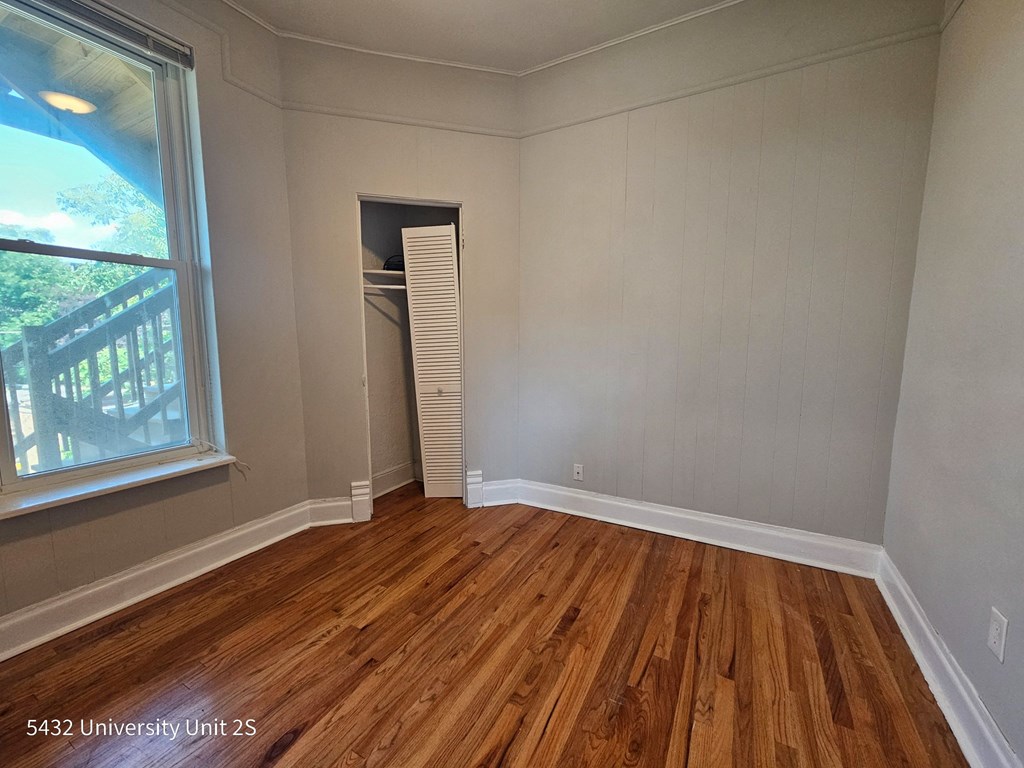 the living room of a house with wooden floors and a large window