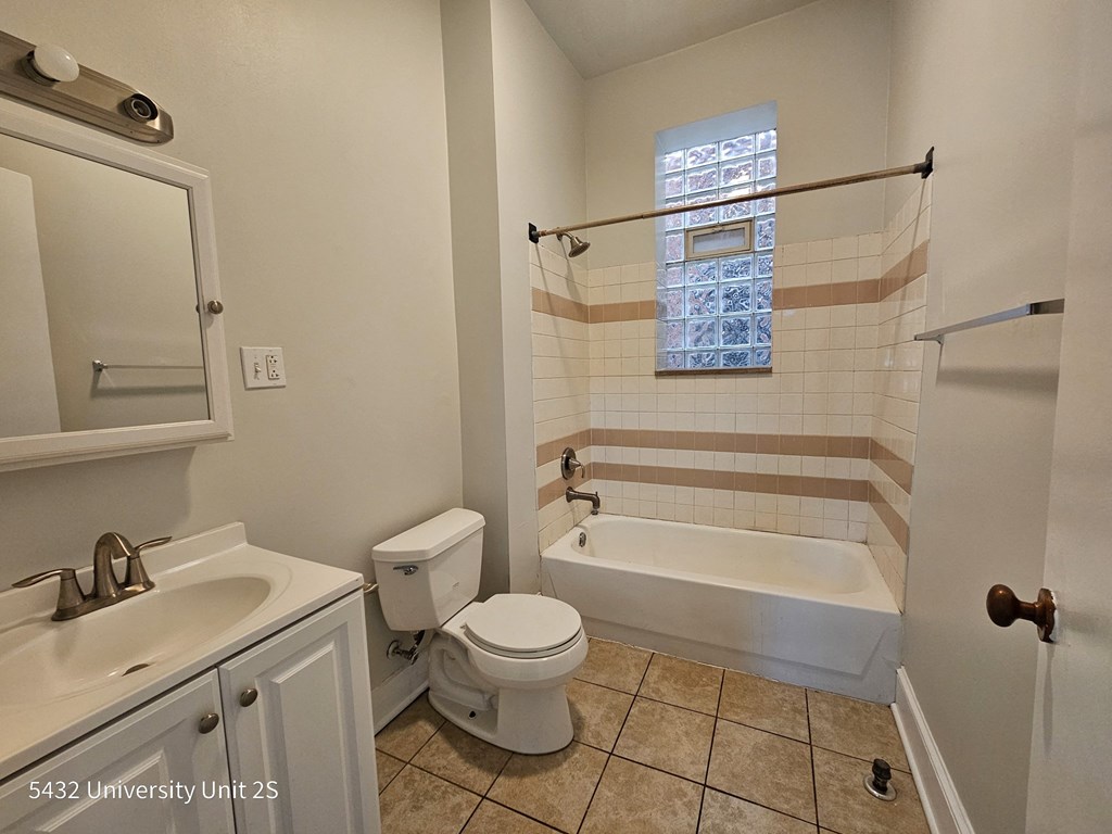 a bathroom with a toilet and a tub and a sink
