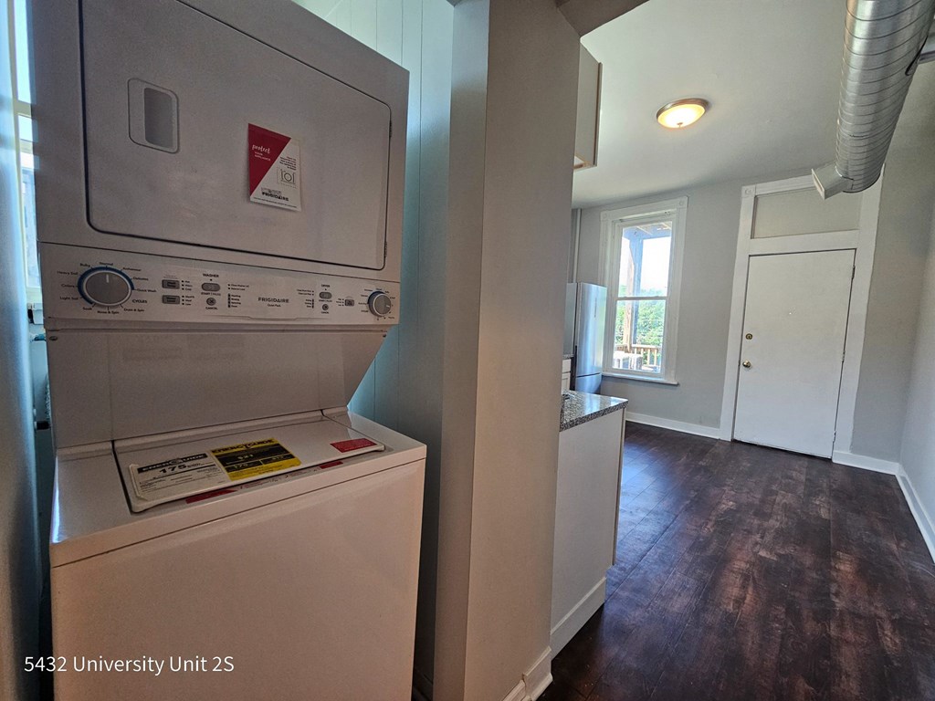 a renovated kitchen with a washer and dryer and a door to a room
