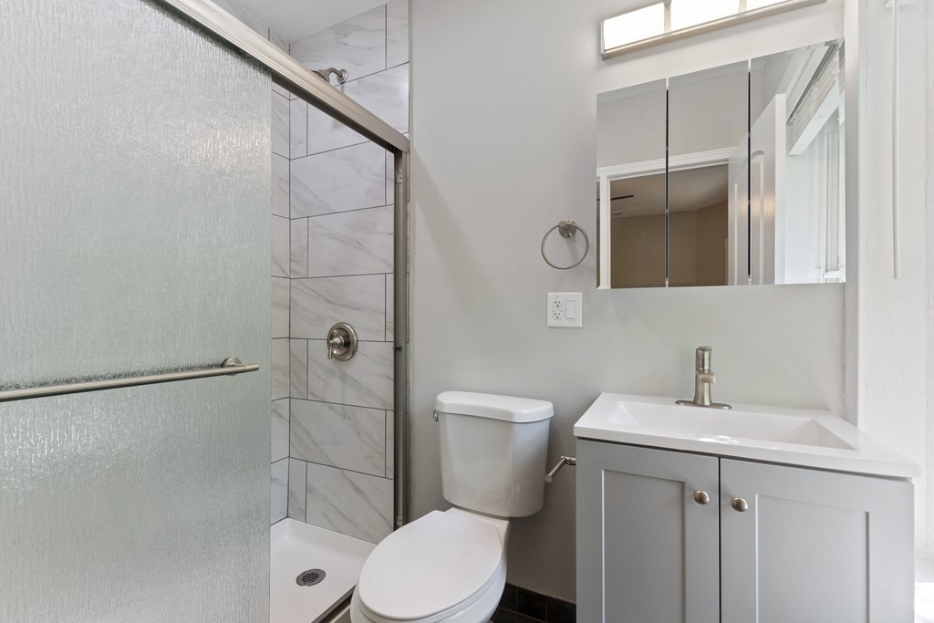 a bathroom with a shower and a sink and a toilet