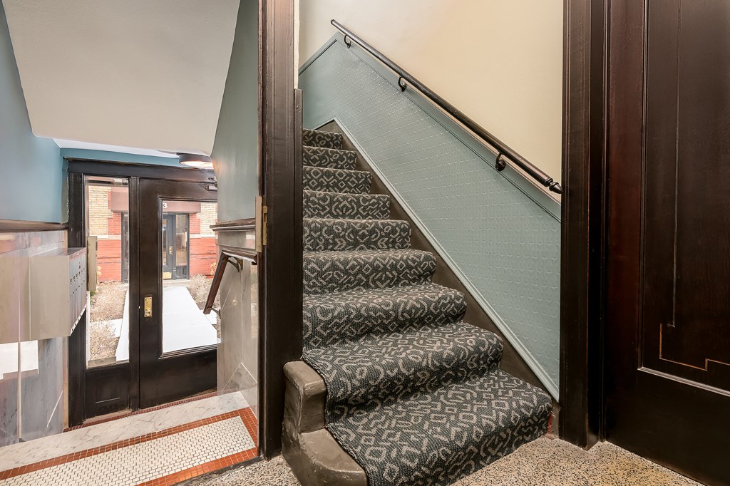 a set of stairs with carpeting leading up to a door