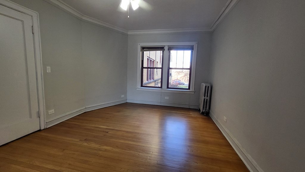 a living room with a window and wooden floors