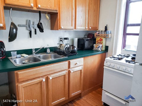 a kitchen with wooden cabinets and a sink and a stove
