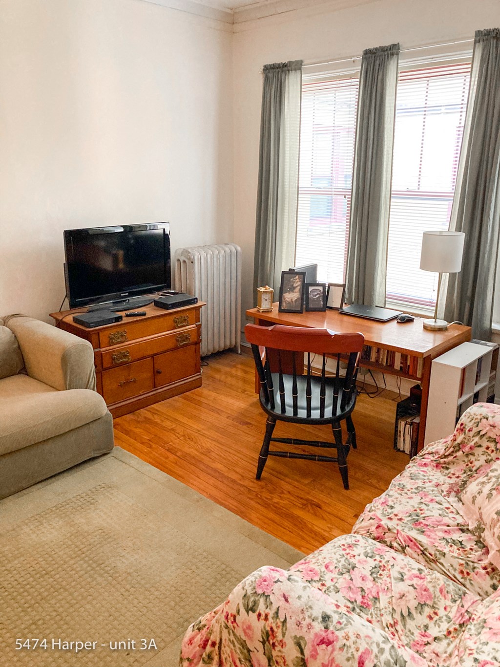 a living room with a couch and a desk and a tv