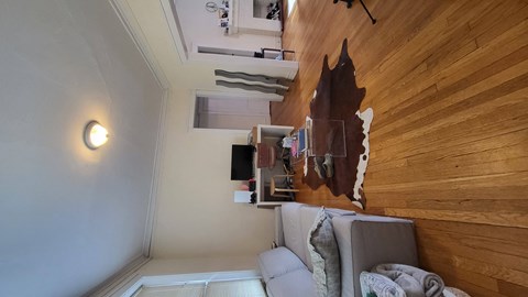 a living room with a couch and a wall with a painting on the wall