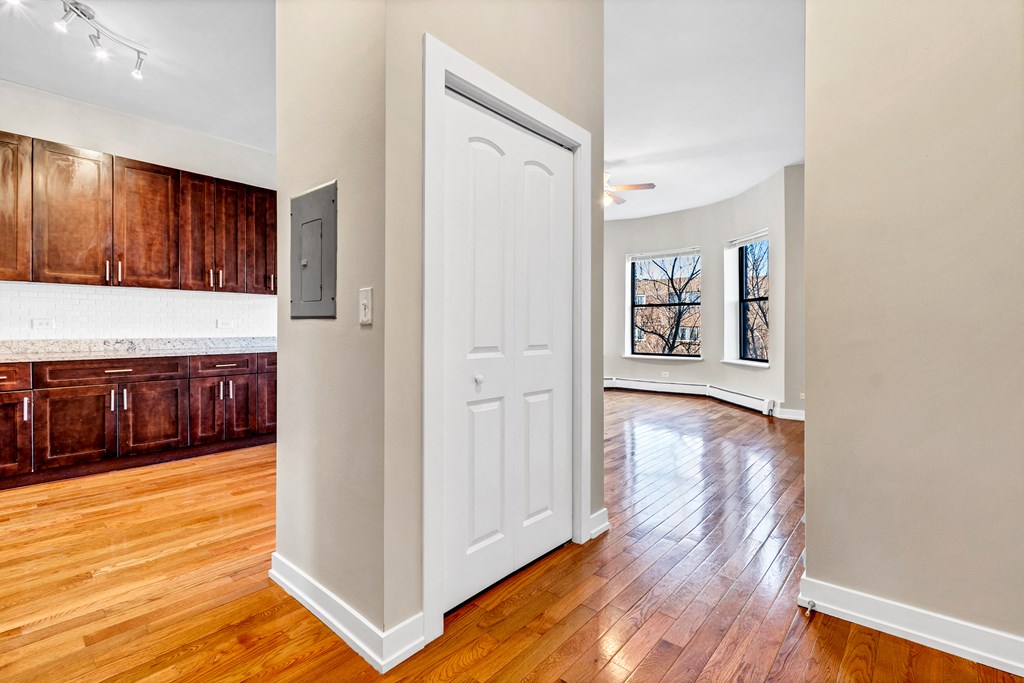 an open door leading into an empty kitchen and living room