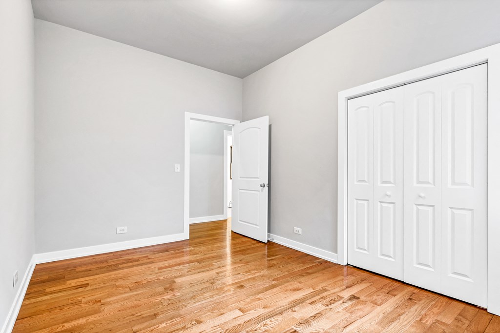 an empty room with wood floors and white doors