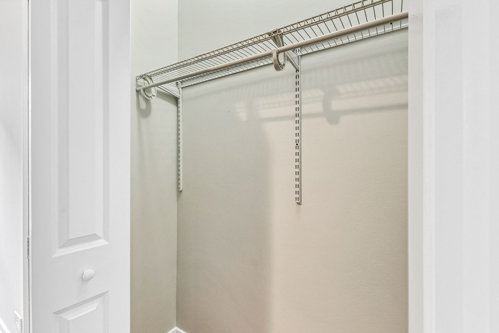 a walk in closet with a hanging rail and a white door