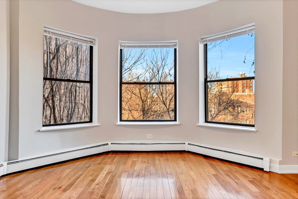 three windows in an empty room with hardwood floors and